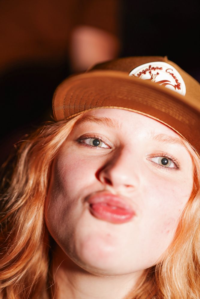Young woman in the Caramel Country trucker, warm indoor light